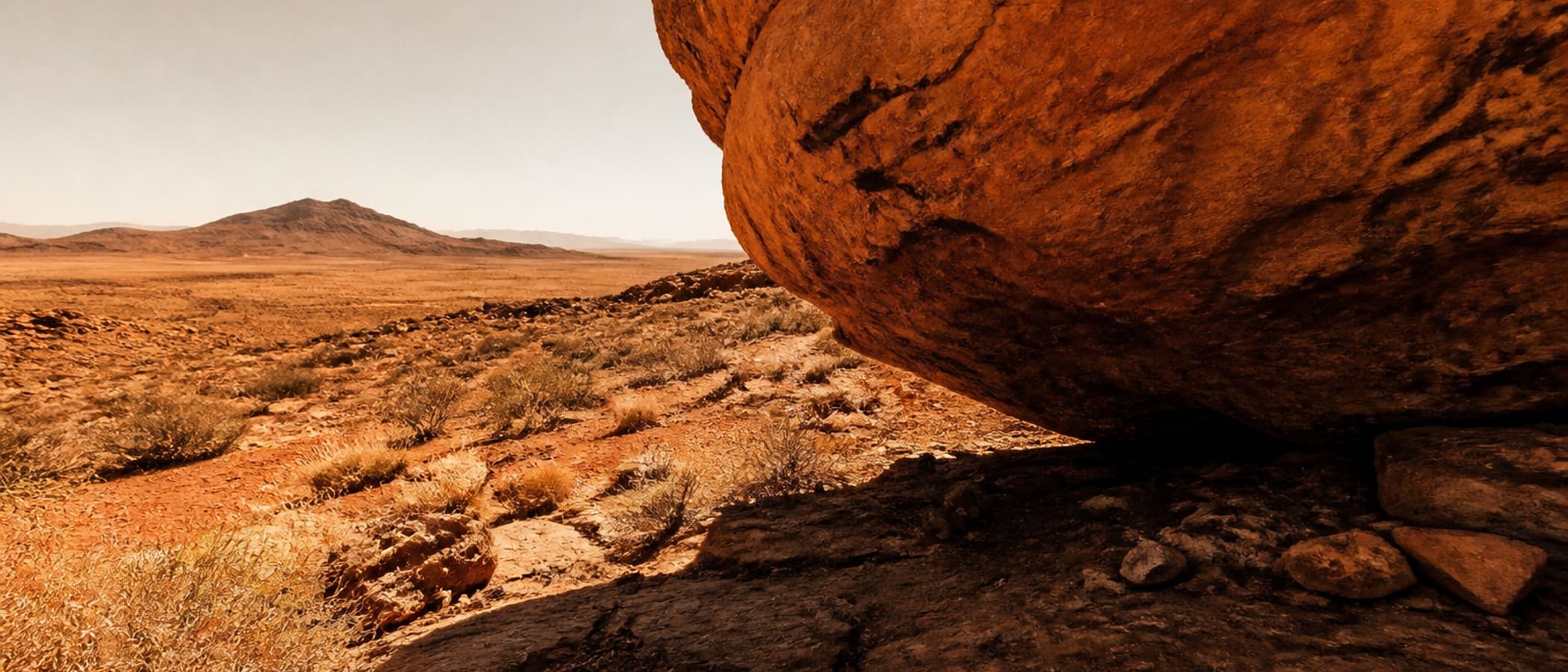 Arid desert rock and scrub under harsh sun and heat haze, the desert survival environment of shade and water discipline